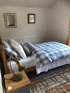 CotgravePlumtree Cottage的一间卧室配有一张床和一张带台灯的桌子