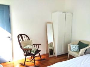 Arazato海之恋的一间卧室配有两张摇椅和镜子