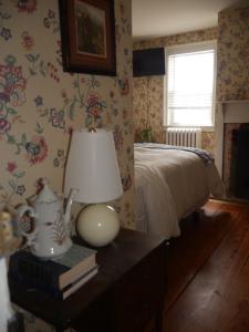 Mays LandingThe Inn at Sugar Hill的一间卧室配有一张床和一张桌子上的台灯