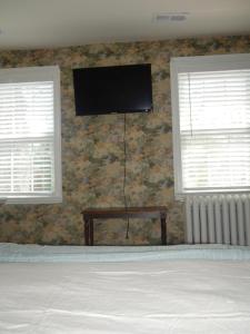 Mays LandingThe Inn at Sugar Hill的卧室设有2扇窗户,墙上设有电视
