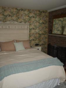Mays LandingThe Inn at Sugar Hill的一间卧室配有一张带花卉壁纸的大床
