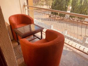 阿布贾Executive Gold Hotel的阳台上配有两把橙色椅子和一张桌子