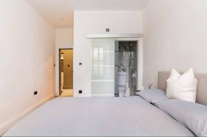 爱丁堡Luxury New Town Apartment的卧室配有一张带白色墙壁的大床