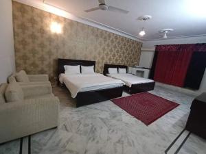 卡拉奇RoyalVilla Guest House Karachi的酒店客房,设有两张床和一张沙发