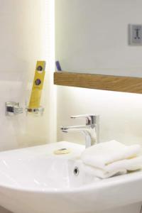 卡拉奇RoyalVilla Guest House Karachi的白色浴室水槽、水龙头和毛巾