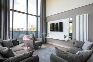 贝尔法斯特Skyline Serenity: Exquisite 3-Bedroom Ultra-Luxury Penthouse的带沙发、电视和窗户的客厅