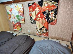南关町Morita-ya Japanese style inn ToraーVacation STAY 62447的卧室的墙上挂着三床被子
