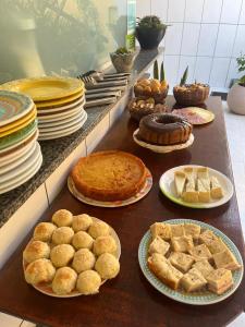 莫罗圣保罗Pousada Sol e Mar的餐桌,包括馅饼和糕点以及食物盘