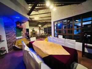 里奥班巴Casa de campo con hermosa vista的一间带桌子和白色椅子的用餐室
