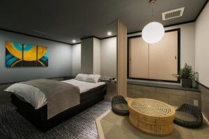 福冈Hotel Ritmo & Gessy ラブホテル的一间卧室配有一张床、一张桌子和一个窗户。