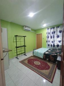 Nibung TebalRizki Homestay的一间卧室设有绿色的墙壁和一张铺着地毯的床