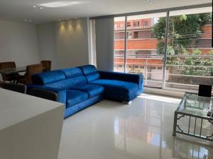 麦德林Medellín, conquistadores 201的配有大窗户的客房内的蓝色沙发