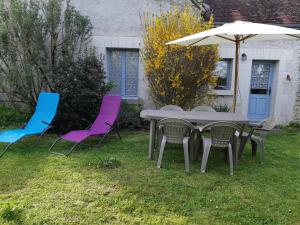 LuzilléGîte Luzillé, 3 pièces, 4 personnes - FR-1-381-303的院子里有三把椅子、一张桌子和一把伞