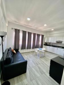 蓬塔卡纳cozy apartment near the beach los corales punta Cana.的客厅配有黑色沙发和桌子