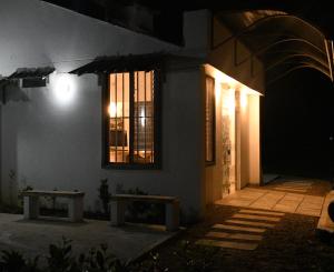 莱蒂西亚Cruz Roja - Turismo Solimões的一座建筑,在晚上前面有两长椅