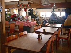 松本乗鞍高原の宿テンガロンハットB&BTengallonhat的一间餐厅,配有桌椅和圣诞树