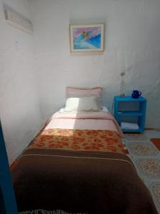 波哥大Casa-Arbol的一间小卧室,配有一张床和一张蓝色的桌子