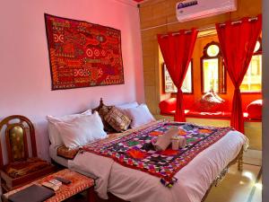 斋沙默尔Hotel Murad Haveli Jaisalmer的一间卧室配有一张带红色窗帘的大床
