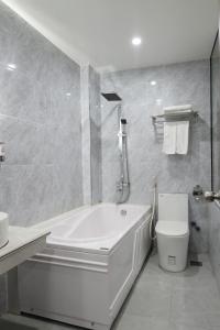 Hạ ÐoạnNgọc Sơn Hotel的白色的浴室设有浴缸和卫生间。