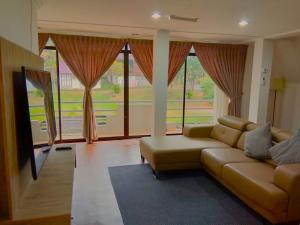 彭亨LiLLA Hilltop Retreats Janda Baik formerly known as Serene Resort的带沙发和大窗户的客厅