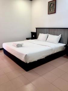 瓜拉丁加奴印丹海滩度假酒店的一间卧室配有一张带白色床单的大床