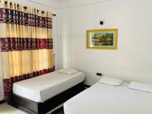 波隆纳鲁沃Hotel Siyathma polonnaruwa的小型客房 - 带2张床和窗户