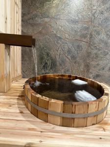 坎莫尔Luxury suite with Sauna and Spa Bath - Elkside Hideout B&B的一个带喷泉的木制浴缸