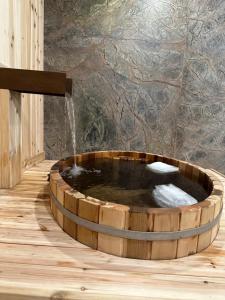 坎莫尔Luxury suite with Sauna and Spa Bath, Dogs Welcome - Elkside Hideout的一个带喷泉的木制浴缸