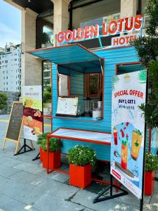 岘港Golden Lotus Hotel Da Nang的一辆蓝色食物车,前面有一张红桌