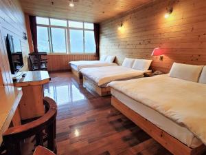 鹿谷乡金台湾山庄的客房设有两张床、一张桌子和一台电视。