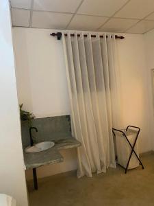 科伦坡Suji's Villa的配有窗帘、水槽和椅子的房间