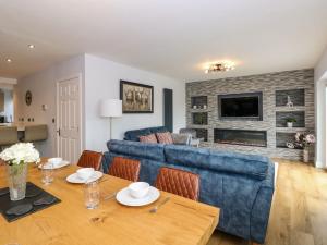 温德米尔Briars Lea的客厅配有蓝色的沙发和桌子