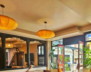加德满都SWARGA HERITAGE HOTEL - A TRADITIONAL STAY的餐厅天花板上悬挂着橙色的灯