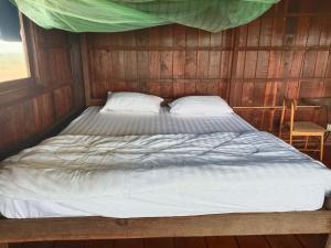 Phumĭ PôyBanlung Hill Top House &Trekking的木墙客房的一张床位