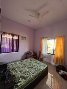GhātgarhRaje Bhosale Farm的一间卧室配有一张带绿色棉被的床和两个窗户。