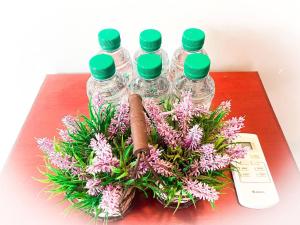 贡布竹制简易别墅度假村的桌子上摆着鲜花,有四瓶水