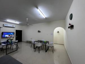 马斯喀特Viva Hostel Group Muscat的一间带桌椅和电视的用餐室