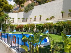 维耶亚高原Belvilla by OYO Casa Panorama Altea Hills的一个带游泳池和棕榈树的度假村