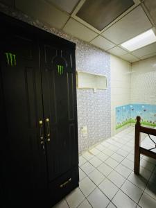 阿布扎比small room PM new location的浴室设有黑色门,上面有绿色数字