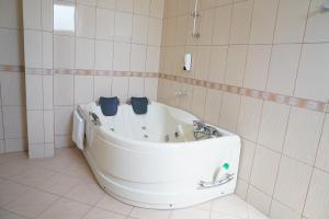 LushnjëHotel Monte Rei的瓷砖浴室设有浴缸。
