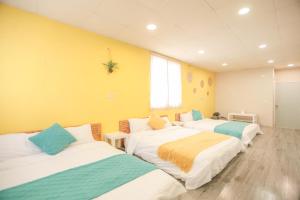 绿岛小巷微光的黄色墙壁的房间里设有三张床