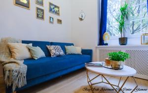 格但斯克BaySide Apartments City Center的客厅配有一张蓝色的沙发,配有一张桌子
