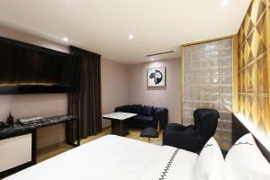 忠州市Gaeul Hotel的酒店客房带一张床、一张桌子和椅子