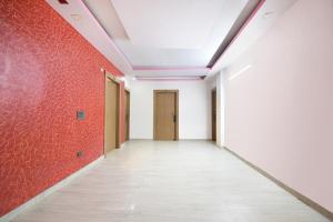 加济阿巴德FabHotel Capital Inn的一条空的走廊,有红色的墙壁和天花板