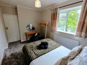 达灵顿The Tansley Gardens的卧室配有床、椅子和窗户。