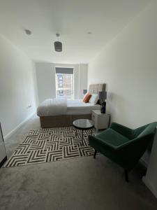 达格纳姆Upper executive apartment的客厅配有床和绿椅