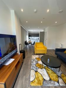达格纳姆Upper executive apartment的客厅设有大电视和黄色沙发
