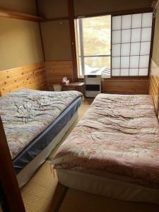 南鱼沼市双子旅馆的一间卧室设有两张床和窗户。