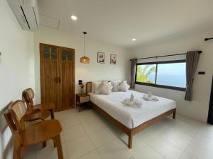 美翰帕岸岛乌托邦度假酒店的一间卧室设有一张床和一个大窗户