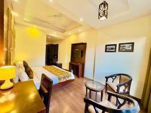 Mai JūbarRadiance valley Resort - A peaceful stay的酒店客房带一张床、一张桌子和椅子
